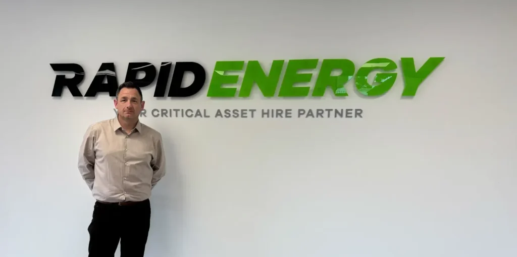 Rapid Energy's new Business Development Manager, Gary Richards, standing by Rapid Energy logo.