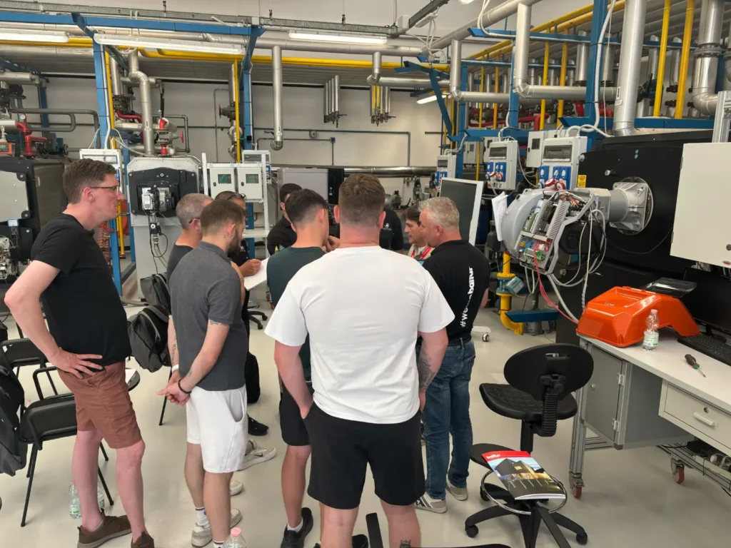 A Rapid Energy engineer and colleagues attending a burner training session, listening to an expert instructor discuss burner technology.
