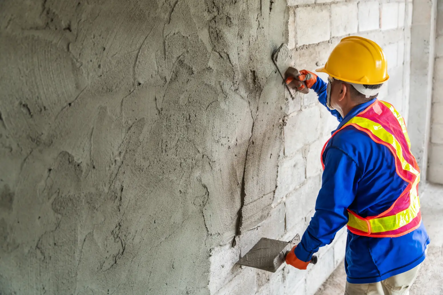 A builder plastering a wall.